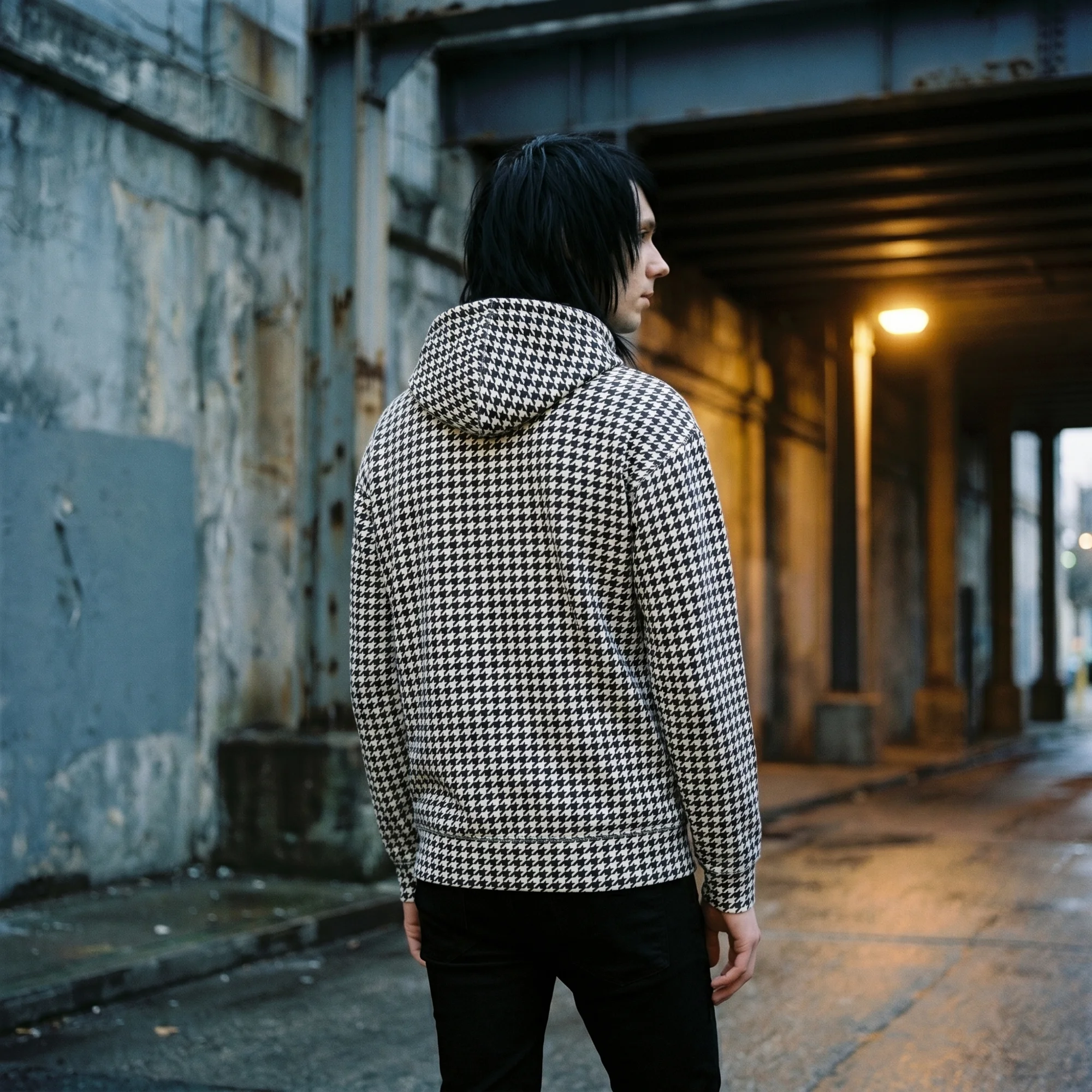 Back view of a man wearing a black and white houndstooth hoodie, showing the fit and hood