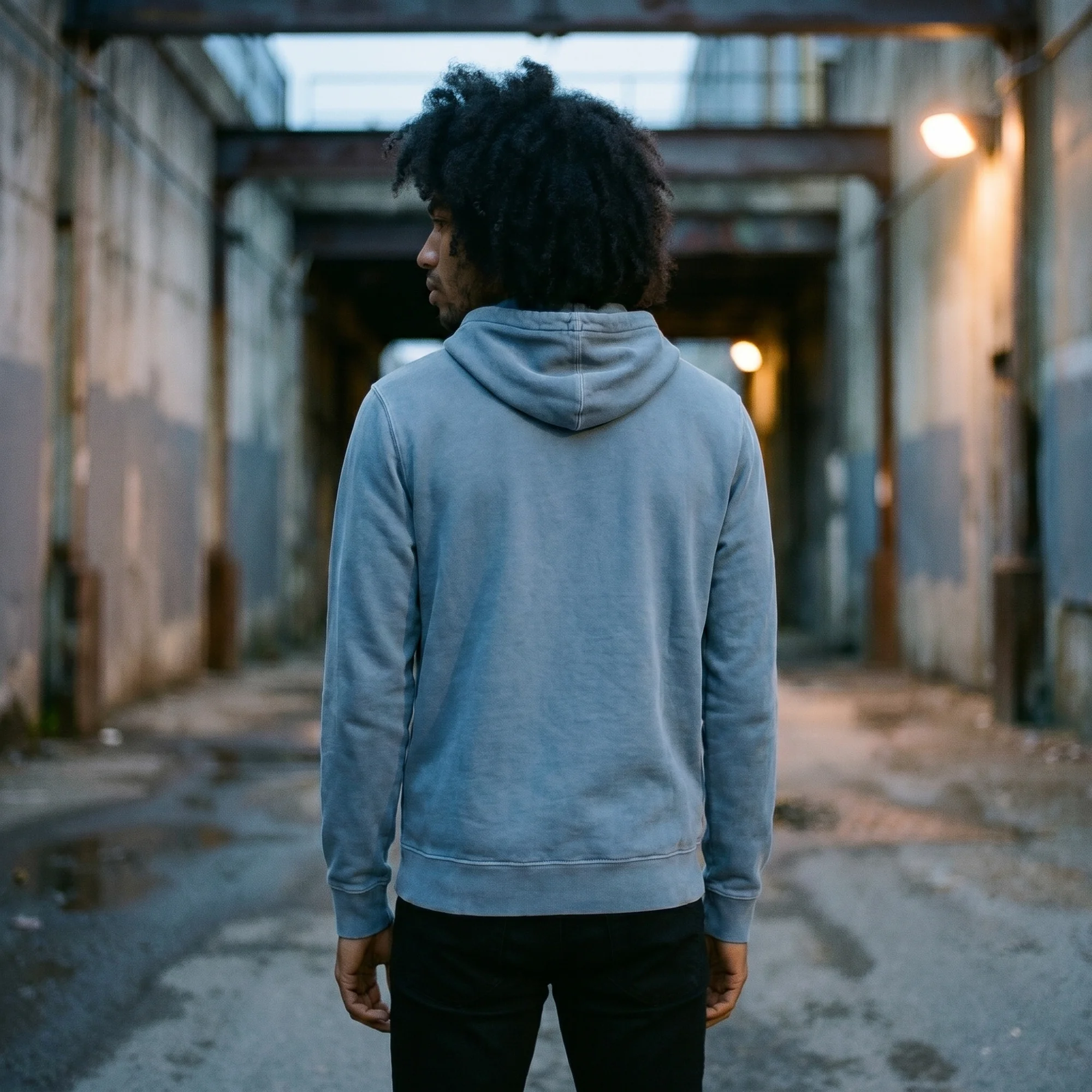 Back view of a man wearing a slate blue pigment dye hoodie, showing the fit and hood