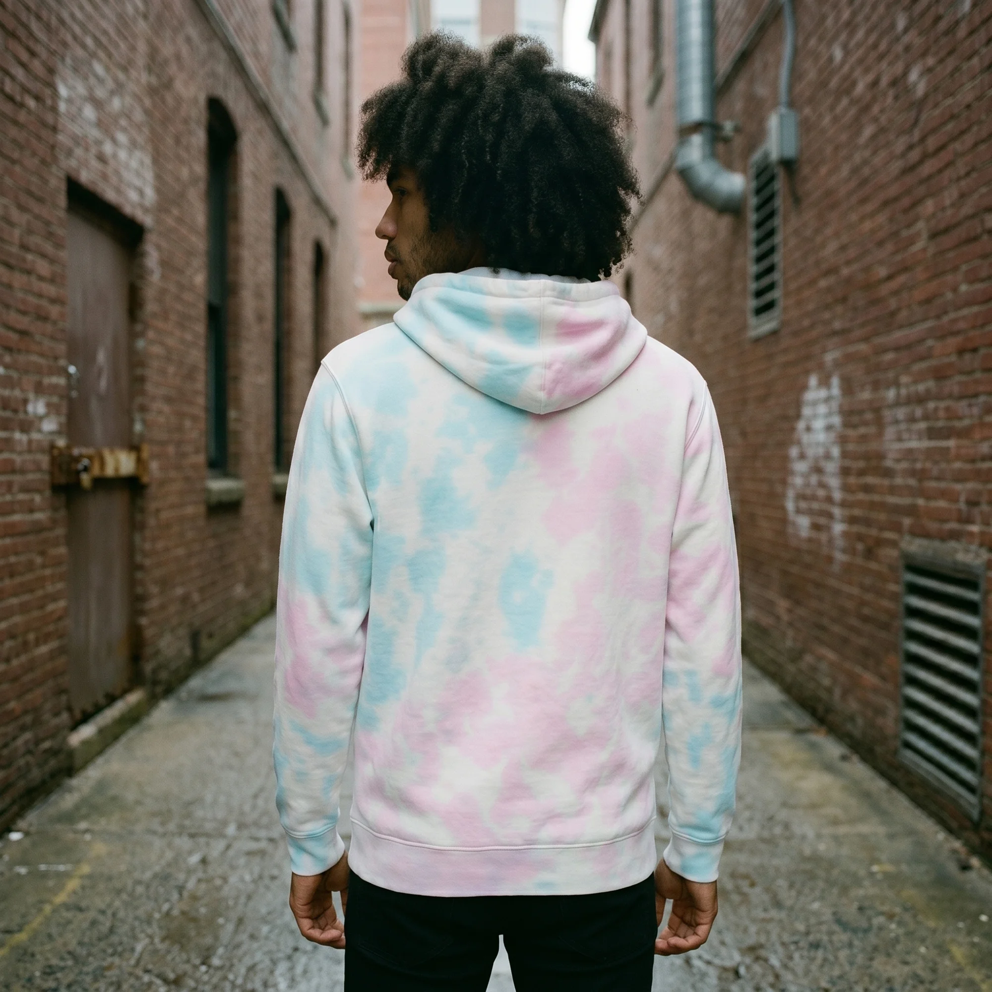 Back view of a man wearing an cotton candy tie-dye hoodie, showing the fit and hood