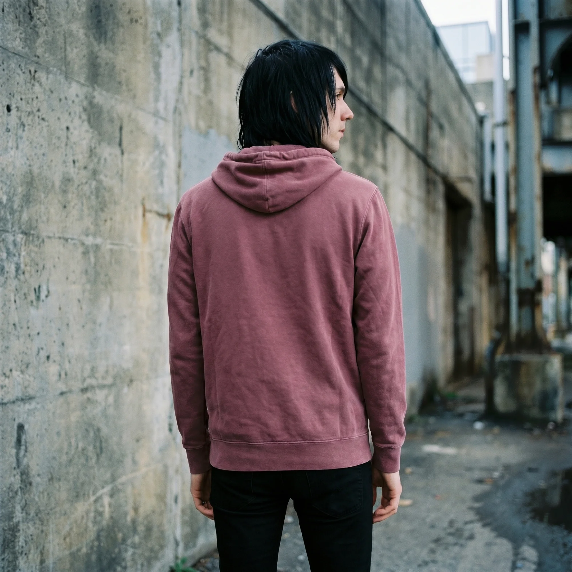Back view of a man wearing a maroon pigment dye hoodie, showing the fit and hood