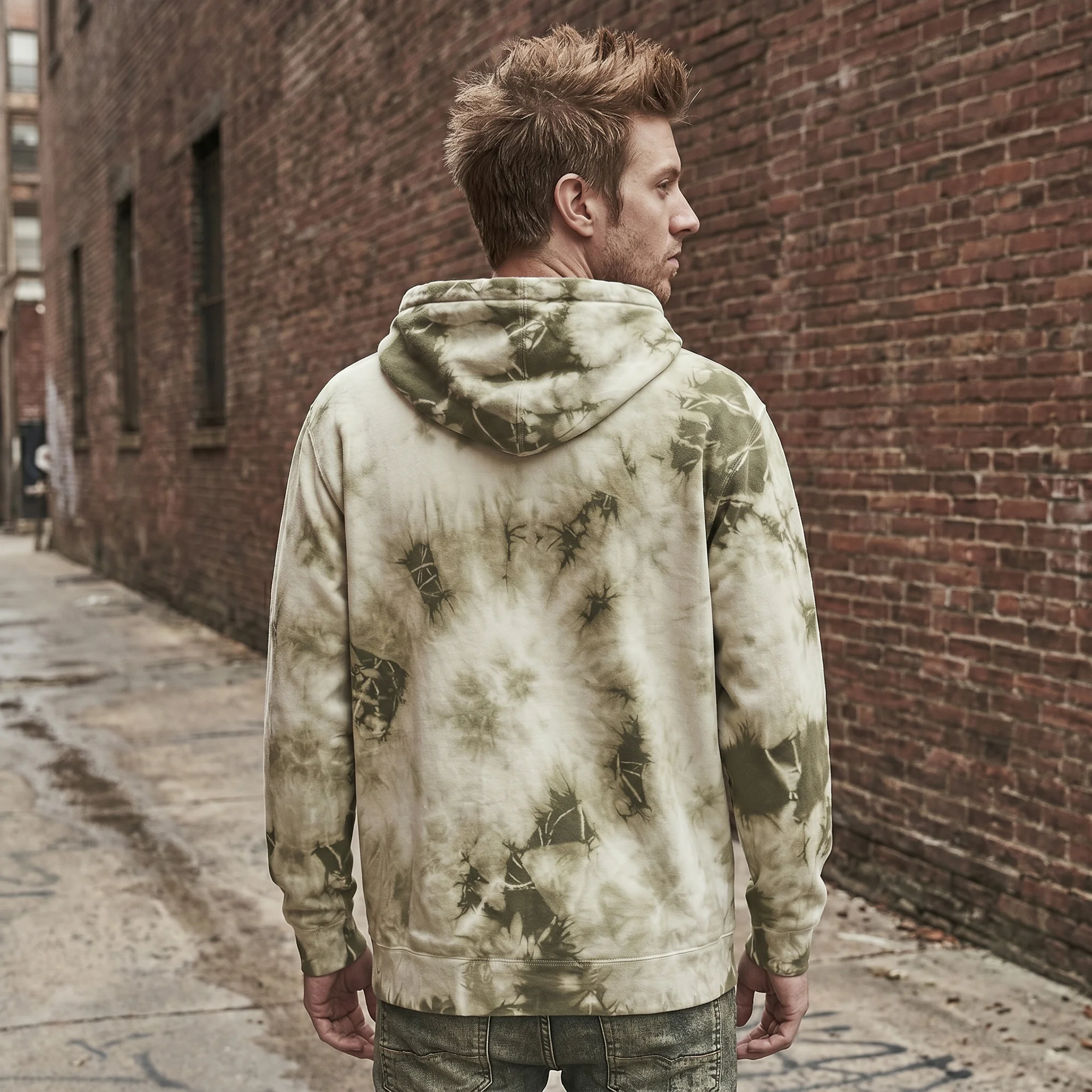 Back view of a man wearing an olive tie-dye hoodie, showing the fit and hood