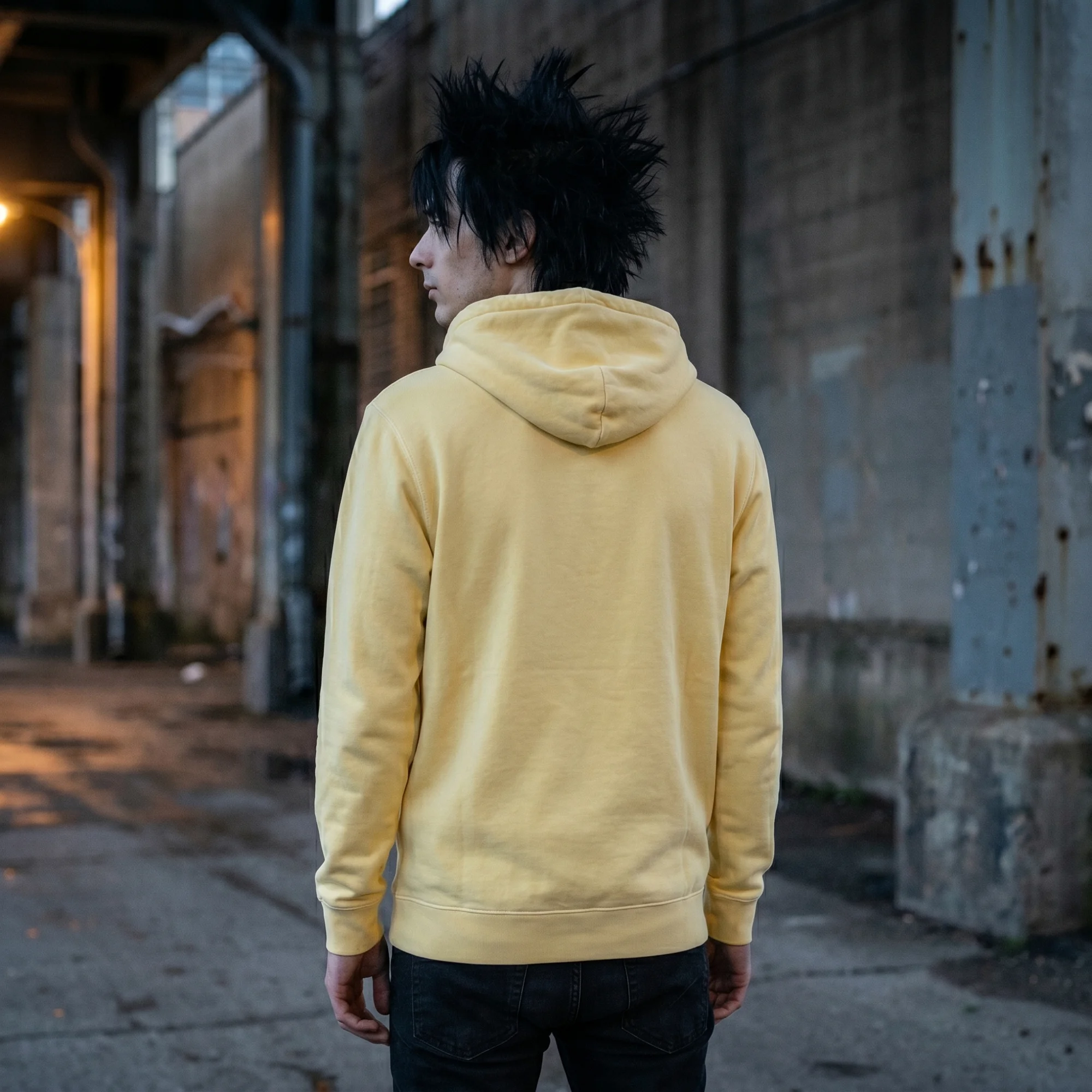 Back view of a man wearing a yellow pigment dye hoodie, showing the fit and hood
