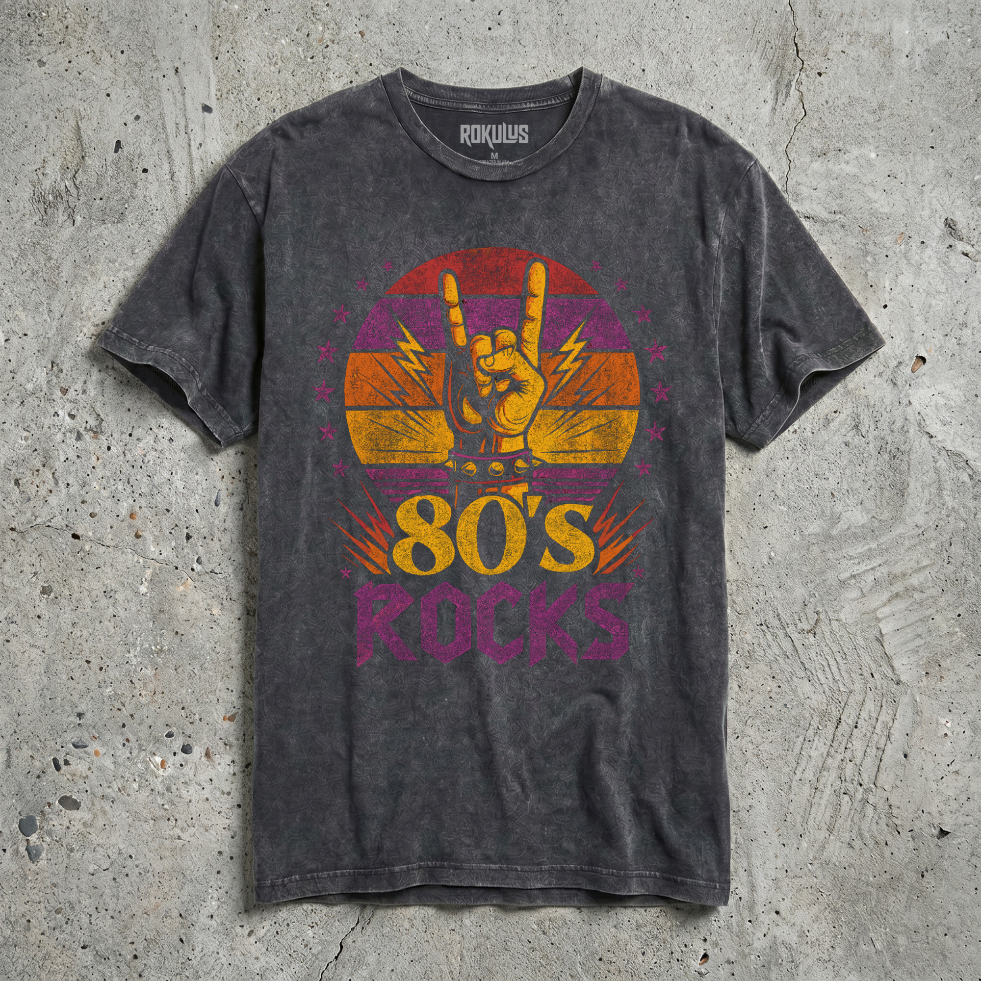 Black vintage wash t-shirt laid flat, showing the 80s Rocks sunset graphic in yellow, orange, magenta, and purple