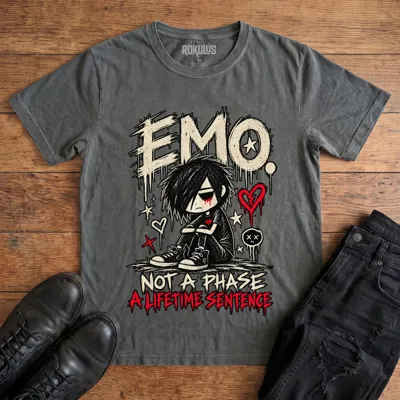 Washed charcoal Rokulus Emo Not A Phase vintage graphic tee laid flat on wood with black boots and jeans, front print showing a moody emo kid hugging his knees under dripping “Emo” lettering with broken hearts and “Not A Phase, A Lifetime Sentence”