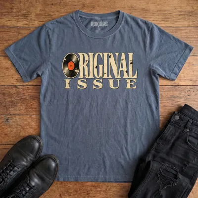 Washed navy blue Rokulus Original Issue vintage graphic tee laid flat on wood with black boots and jeans, front print showing “Original Issue” in distressed vintage serif lettering with a vinyl record forming the letter O