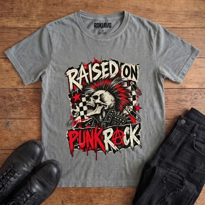 Washed grey Rokulus Raised On Punk Rock vintage graphic tee laid flat on wood with black boots and jeans, front print showing a red-mohawked screaming skull in a studded jacket with safety pins, checkerboard, and an anarchy symbol under “Raised On Punk Rock” lettering