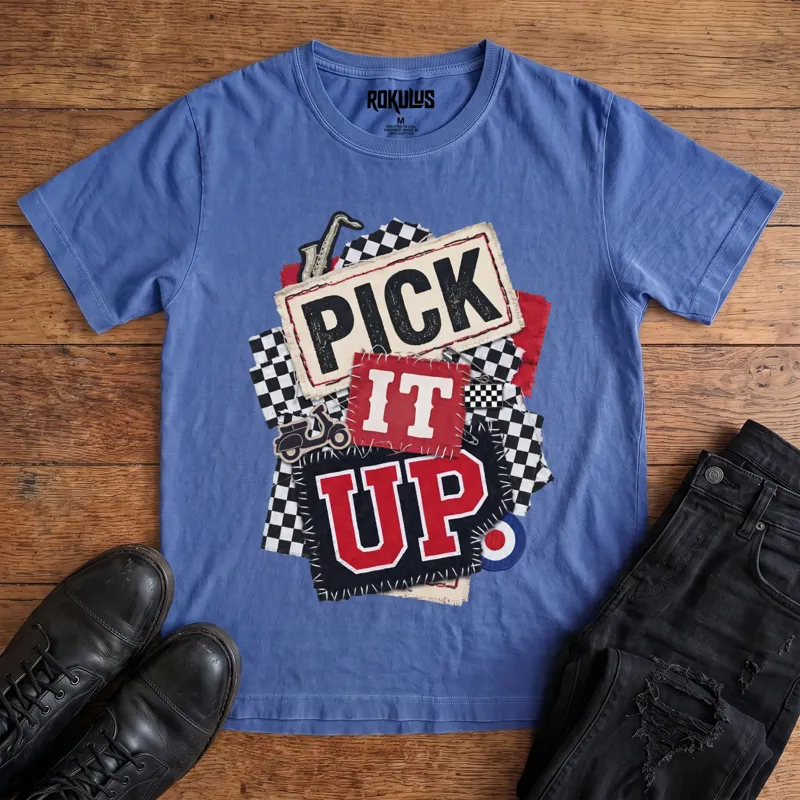 Washed royal blue Rokulus Pick It Up Ska vintage graphic tee laid flat on wood with black boots and jeans, front print showing a 2-tone ska collage with checkerboard, saxophone, scooter, and mod target under stitched "Pick It Up" lettering